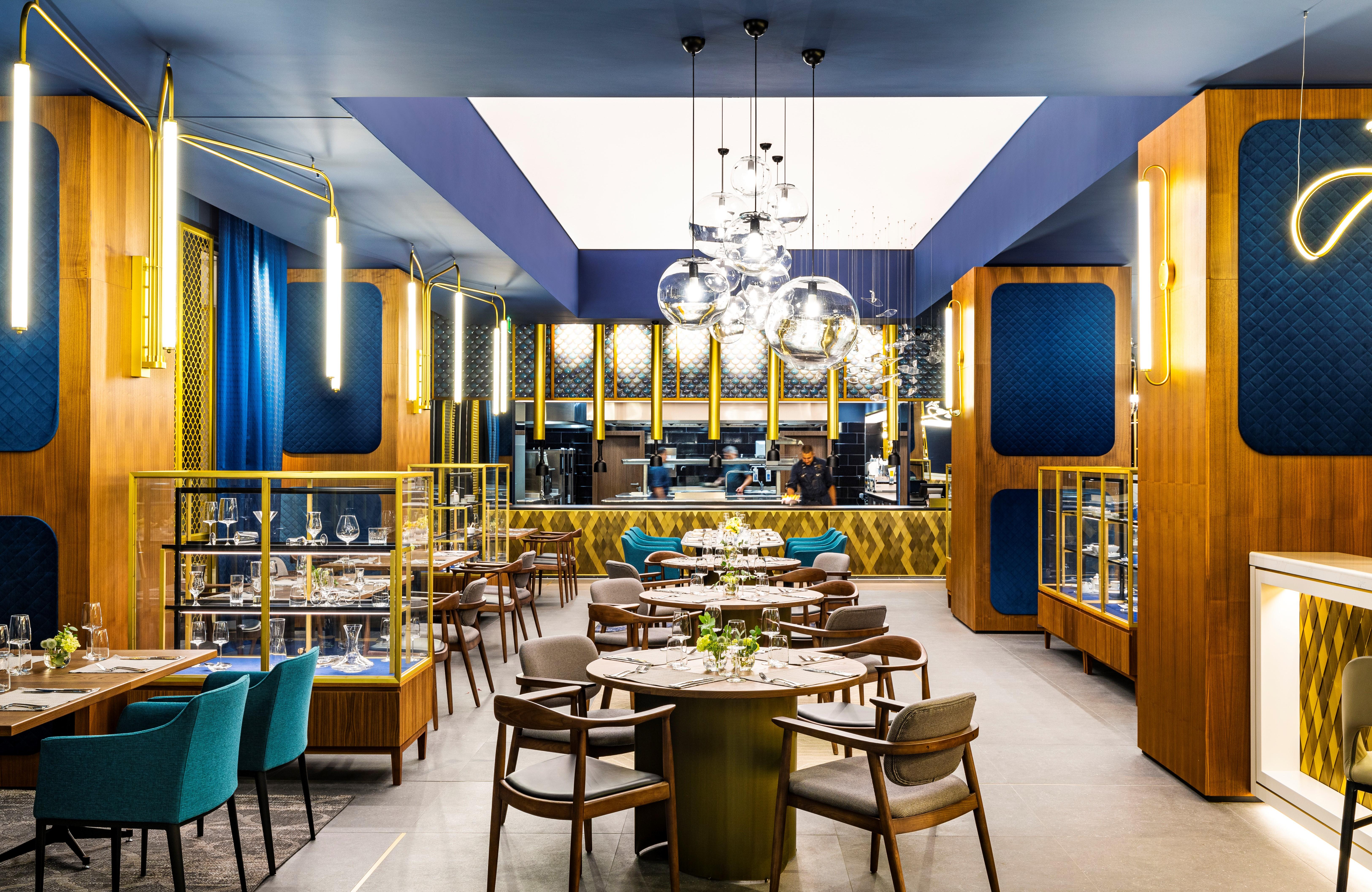 Grand Hotel Millennium 소피아 외부 사진 The photo depicts a modern restaurant interior characterized by sleek and elegant design elements. The space features wooden accents, with warm tones creating an inviting atmosphere. 

Tables are arranged centrally, surrounded by comfortable upholste